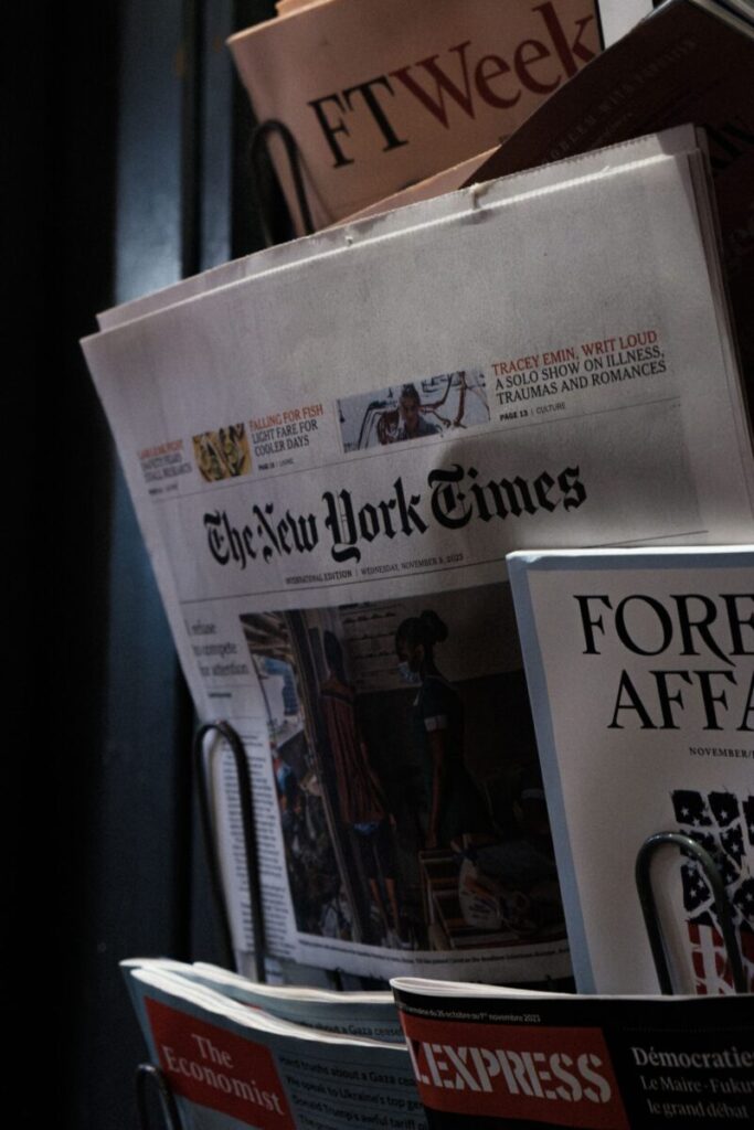A detailed look at a newspaper stand showcasing The New York Times and other publications.